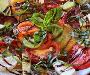 Tomato plate with fresh mozzarella, avocado and balsamic glaze.