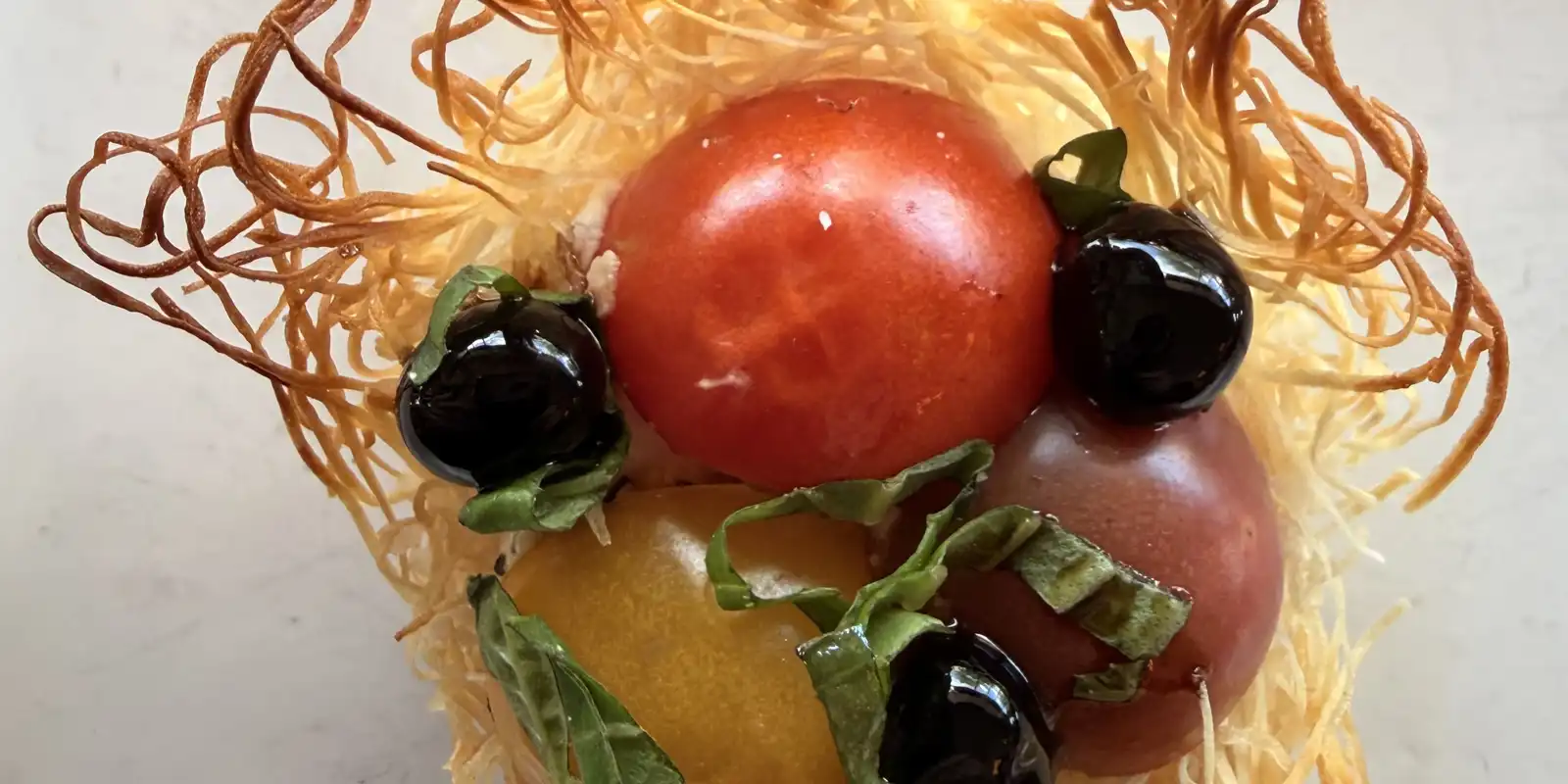 Phyllo nest with baby tomatoes and citrus caviar