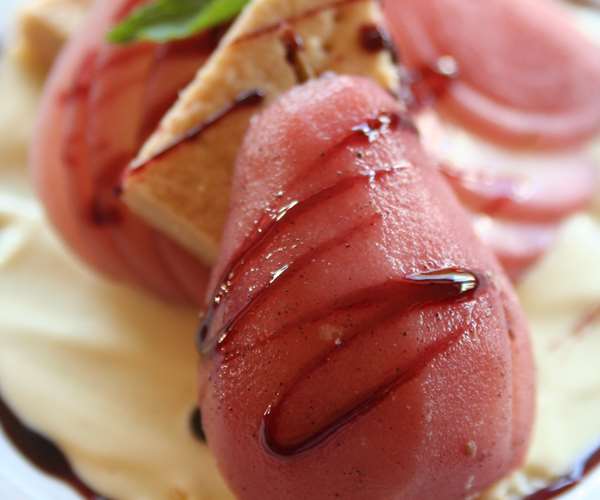 Red wine poached pears served on homemade shortbread cookie with a basil creme anglaise
